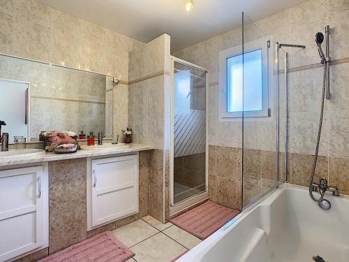 a bathroom with a tub and a shower and a sink at Villa Dedele in Soustons