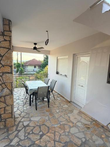 a dining room with a table and chairs on a patio at Maison Pelops Petalidi in Petalidi