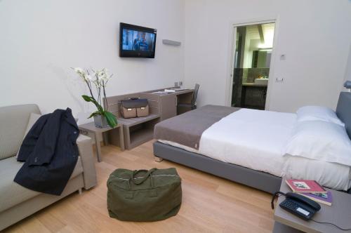 a bedroom with a bed and a couch and a desk at Hotel Di Varese in Varese