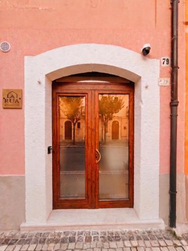 a wooden door in a pink building at Yes I Know My Room - La Rua in Castel di Sangro