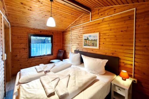 a bedroom with two beds in a wooden wall at Ferienbungalow Seeluft in Loddin