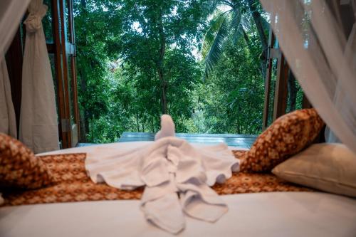 a bedroom with a bed with a view of a window at Ant House Sidemen in Silebeng