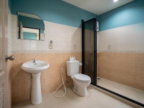 a bathroom with a toilet and a sink and a shower at Orient Hotel in Jomtien Beach