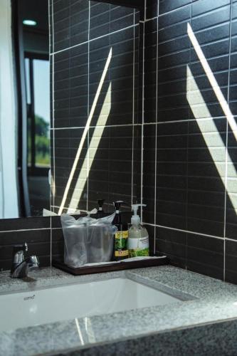 a bathroom counter with a sink and a mirror at โรงแรมคุณหญิงโฮเตล in Nan