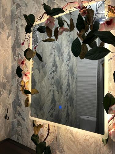 a mirror in a bathroom with a plant at Дача в городе in Bishkek