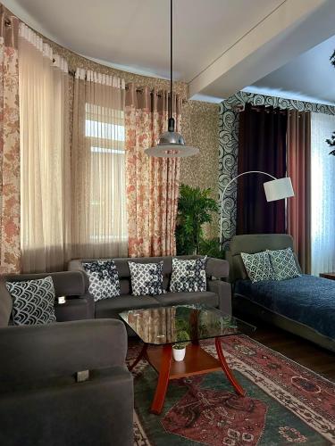 a living room with a couch and a table at Дача в городе in Bishkek