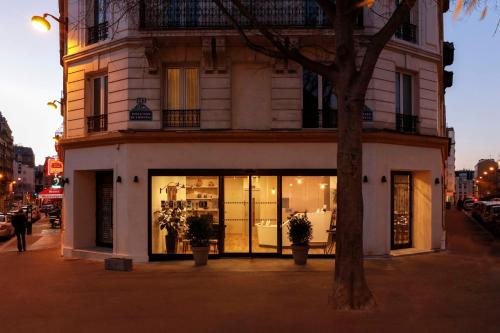 a store front of a building on a city street at Hôtel Coypel by Magna Arbor in Paris