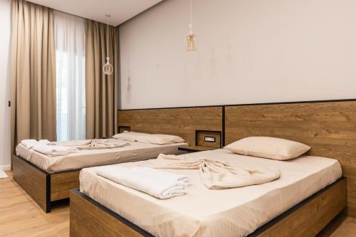 two beds in a room with a large screen at Ambra & Arber Hotel in Bogovë