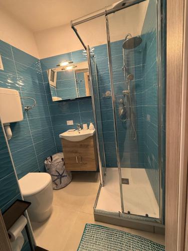 a bathroom with a shower and a toilet and a sink at Maja cuore blu in Vieste