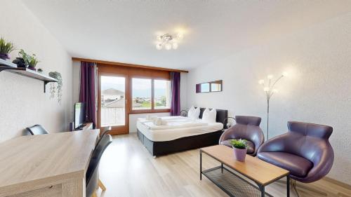 a living room with a bed and a table and chairs at Bright studio in Saillon, a few steps from Les Bains in Saillon