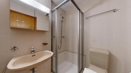 a white bathroom with a sink and a shower at Bright studio in Saillon, a few steps from Les Bains in Saillon