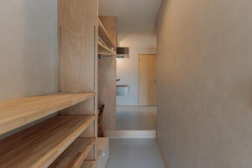 ein Zimmer mit Holzregalen und ein Flur in der Unterkunft cuccou in Aira