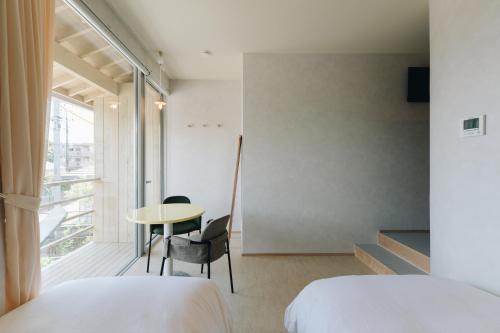 ein Schlafzimmer mit zwei Betten, einem Tisch und einem Fenster in der Unterkunft cuccou in Aira