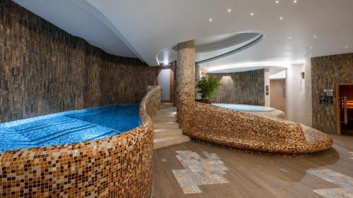 a room with a large bed and a bath tub at Wellton Riga Hotel & SPA in Riga