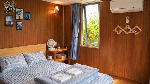 a bedroom with a bed and a window at Cổ Thiên Thạch Kiếm in Ðại Lào