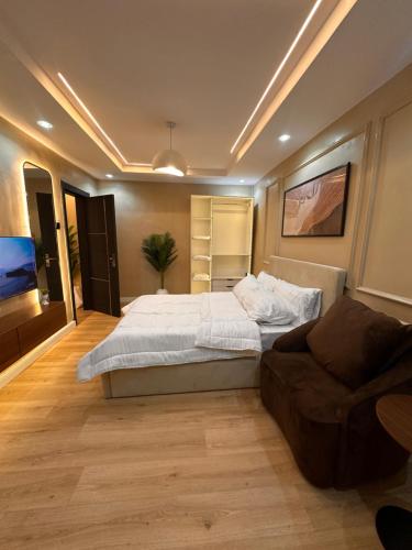 a bedroom with a large bed and a couch at Pedro suite by iconic apartment in Lagos