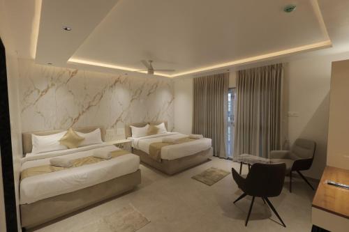 a hotel room with two beds and a couch at Hotel Krushnai Deluxe in Nandre