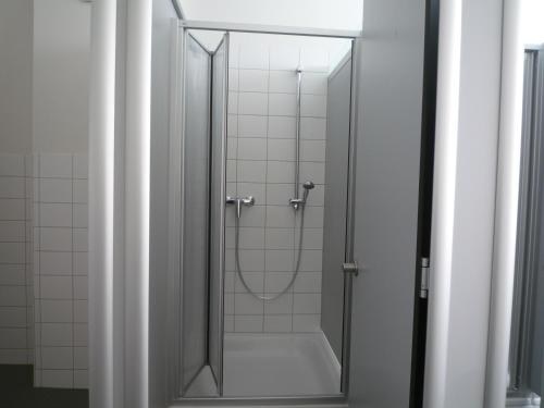 a shower with a glass door in a bathroom at Hostel Stralsund in Stralsund