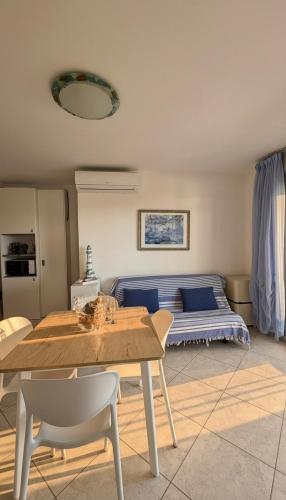 a living room with a table and a bed at Vista Mare a Isola Verde in Isola Bacucco