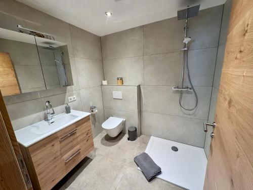 a bathroom with a toilet and a sink and a shower at Haus Bodner in Kartitsch