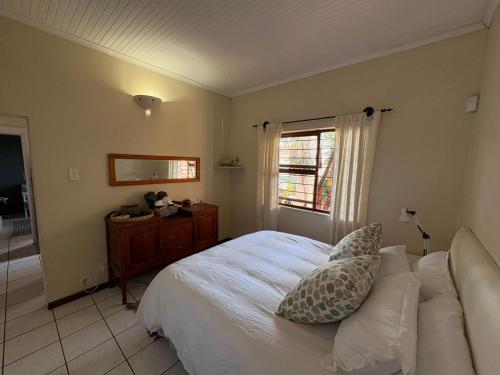 a bedroom with a white bed and a window at The Sync Inn in Gqeberha
