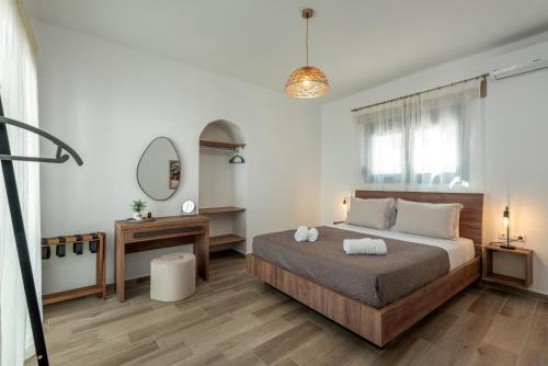 a bedroom with a bed and a desk and a mirror at Tholos Home Sfakia in Hora Sfakion