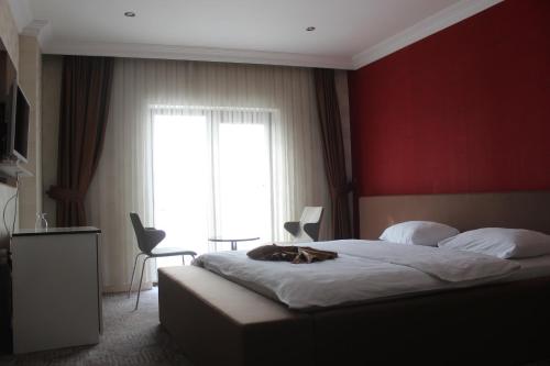a bedroom with a large bed with a red wall at Hotel Dosco in Van