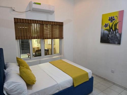 a bedroom with a bed with yellow sheets and a window at Casa Solare in Wellawatta