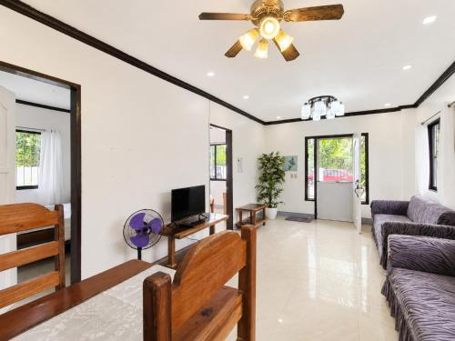 a living room with a ceiling fan and a couch at Yayay Siargao - Generator & Starlink in General Luna