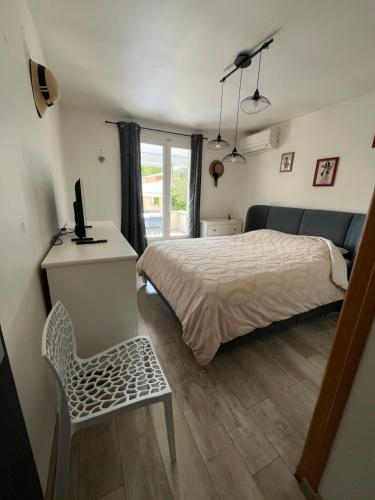 a bedroom with a bed and a desk and a chair at "Villa du Pin" idéalement situé Ruoms à pieds, voie verte in Ruoms