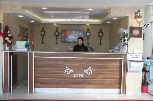 a man sitting at a counter in a store at Hotel Dosco in Van