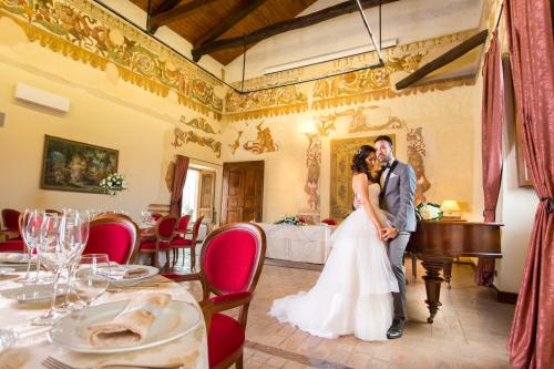 a bride and groom posing for a picture in a room at Castello di Altomonte in Altomonte