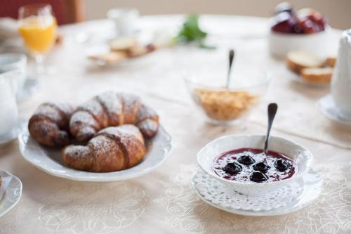 a table with a plate of pastries and a bowl of jam at Castello di Altomonte in Altomonte