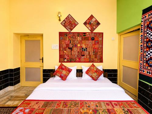 a bedroom with a white bed with colorful pillows at Hotel Robin Jaisalmer Near fort view in Jaisalmer