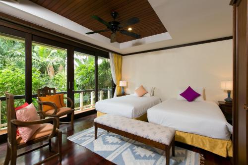 a bedroom with two beds and a balcony at Katamanda Villa Chanti Pool Villa Kata in Kata Beach