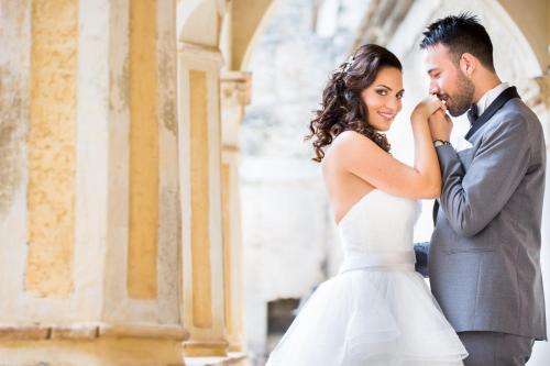 a bride and groom posing for a picture in front of a building at Castello di Altomonte in Altomonte