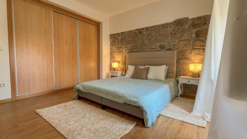a bedroom with a bed with two tables and two lamps at Casa do Sobrado ByAlta in Caparrosa