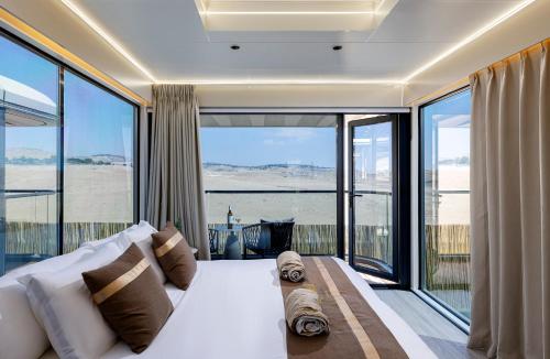 a bedroom with a large bed and large glass windows at Kassland Resort & Spa -By Kassland Hotels in Ma'ale Adumim