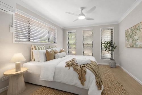 a white bedroom with a large white bed and windows at Blue Gum Hideaway Pet friendly Fire Pit in Coolum Beach