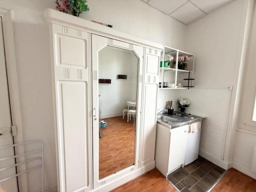 a white room with a mirror and a kitchen at Studio plein centre et parking in Châtel-Guyon