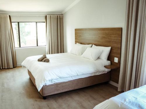 a bedroom with a bed with a teddy bear on it at Railway Hotel in Wellington