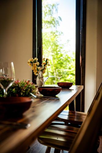 a wooden table with two glasses and flowers on it at Casa Sunetul Padurii din Belis Apuseni in Călăţele