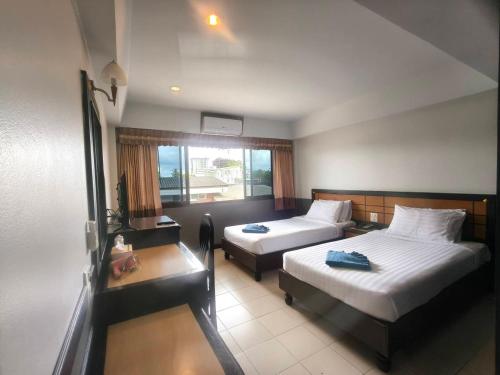a hotel room with two beds and a window at Ariya inn Chiangrai in Chiang Rai