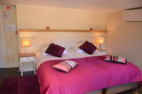 a bedroom with a large pink bed with two lamps at Villa Amylia & gratis parking in Wenduine