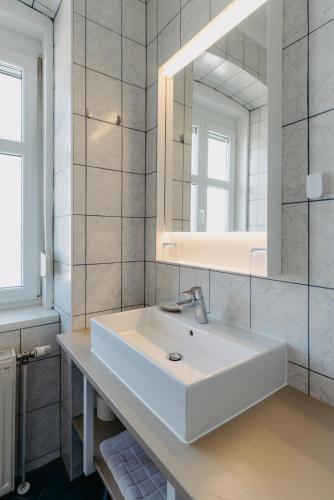 a white bathroom with a sink and a mirror at Das Sonnengleis in Lutzmannsburg