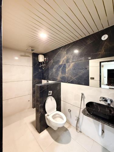 a bathroom with a toilet and a sink at Hotel Vivanta in Bānswāra