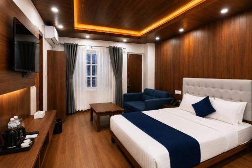 a bedroom with a bed and a chair and a television at Hotel happy stay inn in Pashupatināth