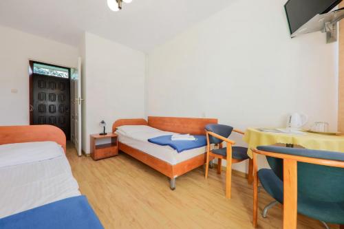a room with a bed and a table and chairs at OW Posejdon Jastarnia - blisko morza i nad zatoką in Jastarnia