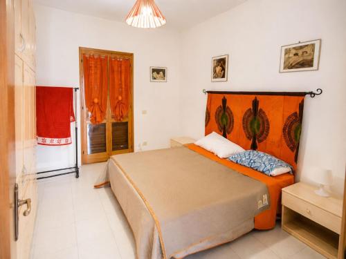 a bedroom with a bed with an orange headboard at Cala Rossa 35 Wit Pool - Elba Affitti in Nisporto