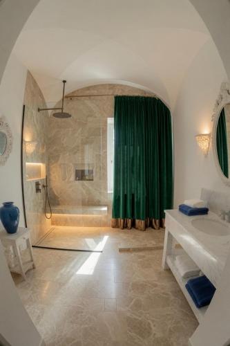 a bathroom with a shower with a green curtain at Home Mykonos lux in Casoria